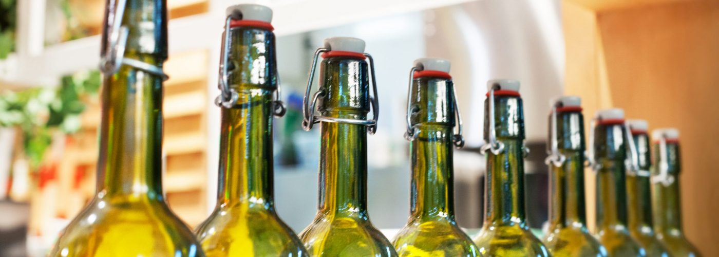 Green,Glass,Bottles,Of,Wine,In,Line,On,Wood,Shelf,